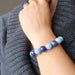 female hand on neck wearing lapis angelite bracelet