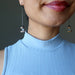 sheila of satin crystal wearing angelite Hopi bean and wood bead dangling earrings