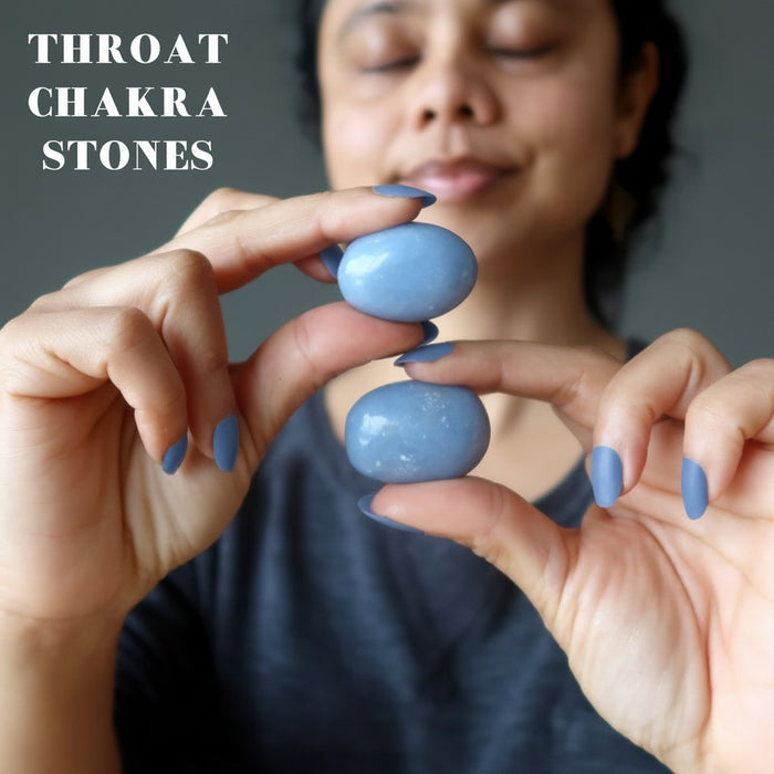 woman holding two angelite tumbled stones
