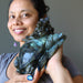 sheila of satin crystals holding a big labradorite dragon turtle carving 