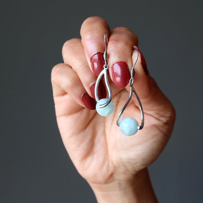 hand holding aquamarine earrings
