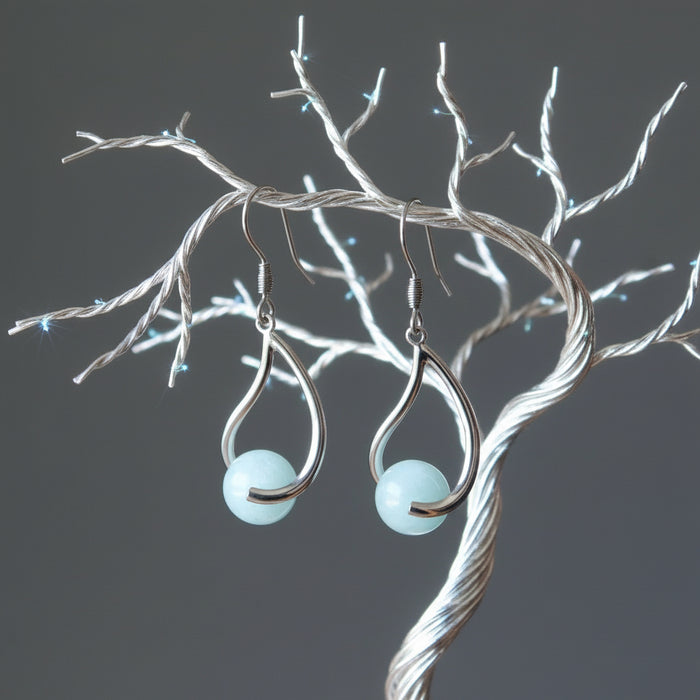 hand holding aquamarine earrings