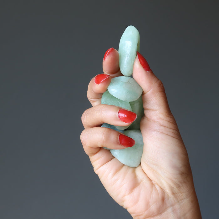 hand holding aquamarine tumbled stones
