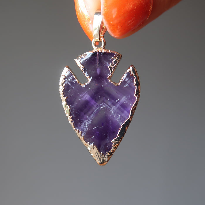 holding purple Arrowhead gold plated framed Amethyst Pendant