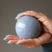 hands holding a blue aventurine sphere