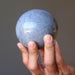 hands holding a blue aventurine sphere