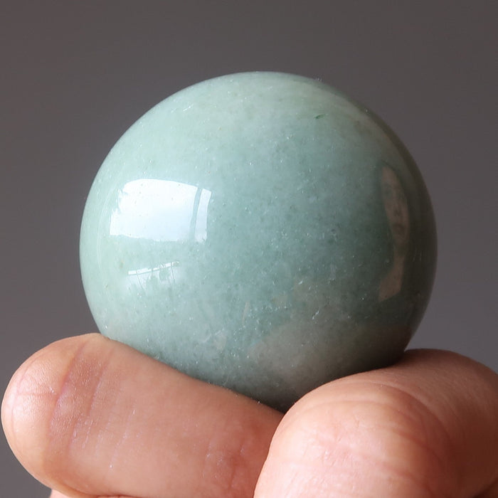 hand with green aventurine crystal ball