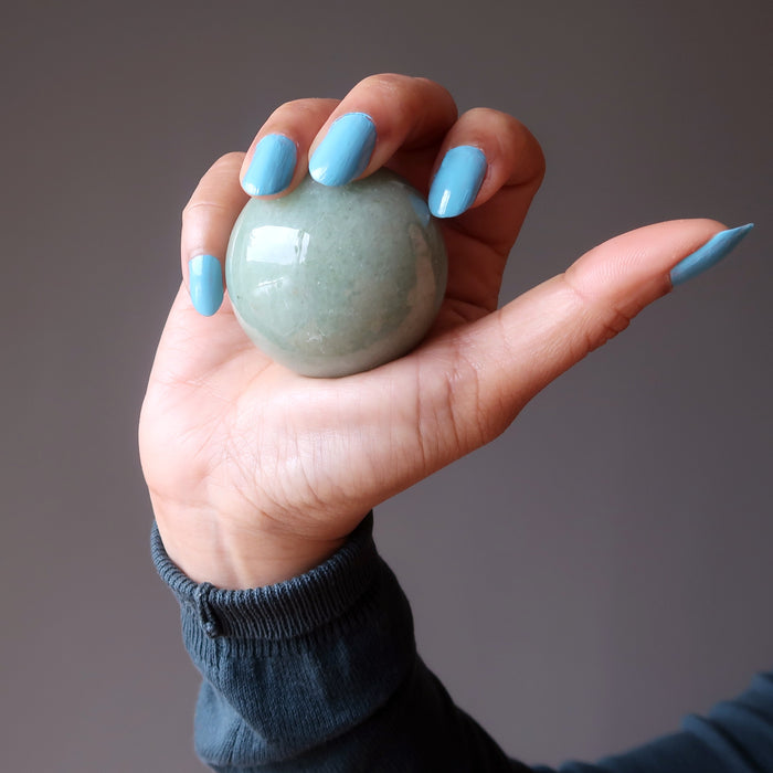 hand holding green aventurine crystal ball