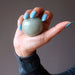 hand holding green aventurine crystal ball