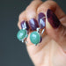 hands holding green aventurine circles in sterling silver earrings