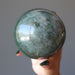 hand holding green aventurine sphere