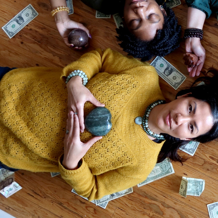 women lying on floor with dark green aventurine heart on chest