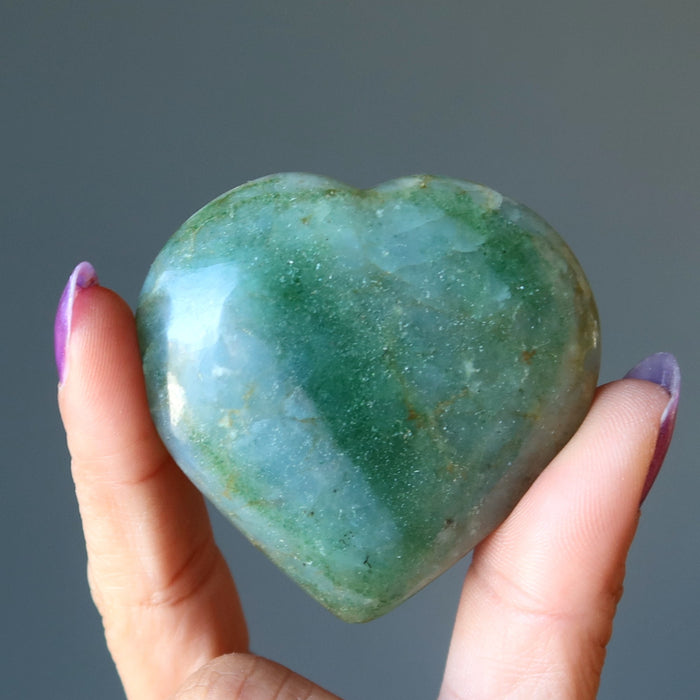 hand holding dark green aventurine heart