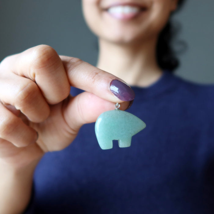 hand holding aventurine bear pendant at chest