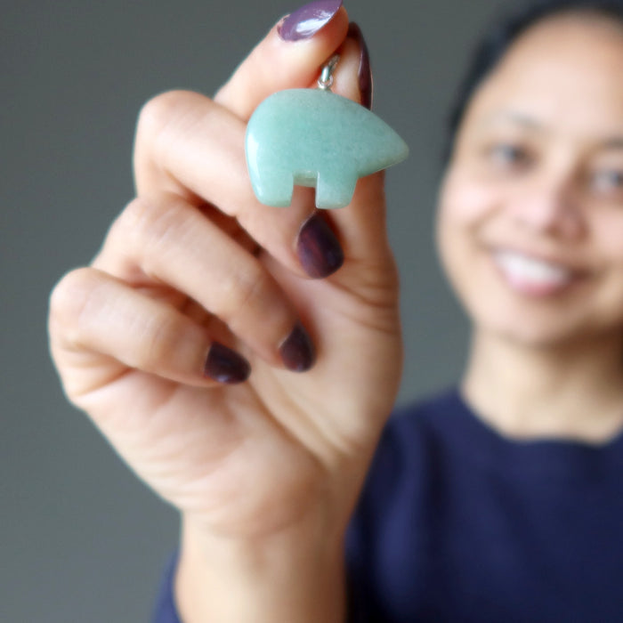 hand holding aventurine bear pendant