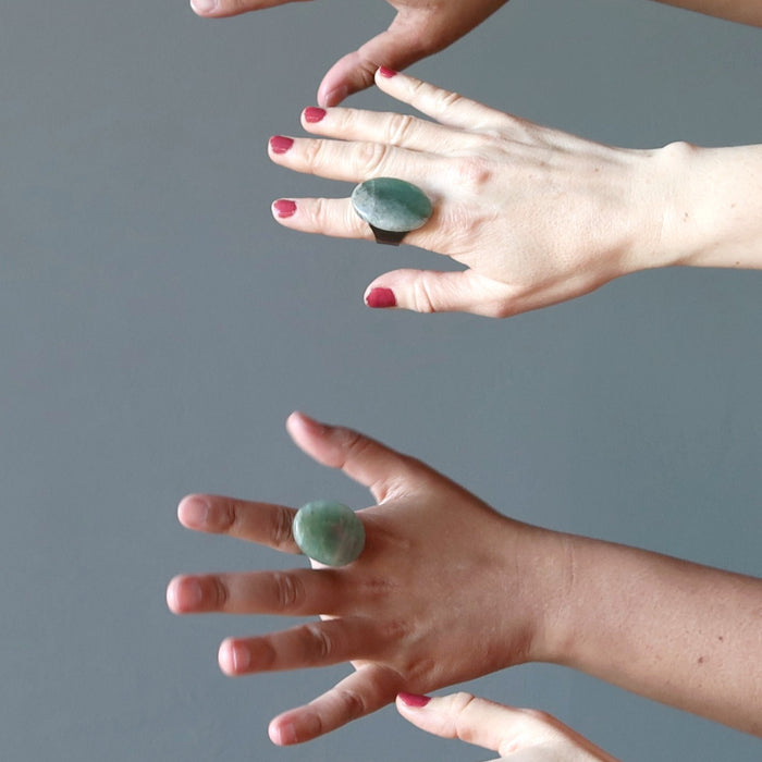 two sets of hands wearing big green aventurine oval adjustable ring