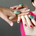 three hands wearing big green aventurine oval adjustable rings