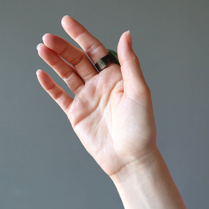 hand wearing big green aventurine oval adjustable ring showing the back adjustable metal