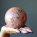 hand holding pink aventurine sphere