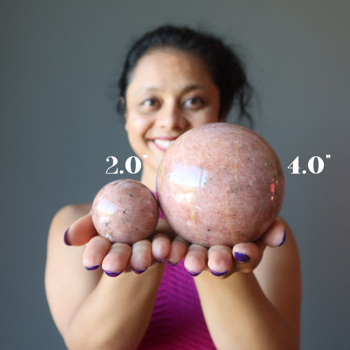 sheila of satin crystals holding two aventurine spheres