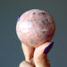 hand holding pink aventurine sphere