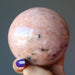 hand holding pink aventurine sphere