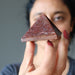 female holding red aventurine pyramid