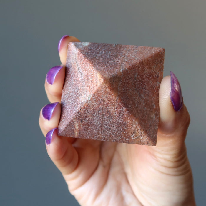 hand holding pink aventurine pyramid