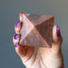 hand holding pink aventurine pyramid