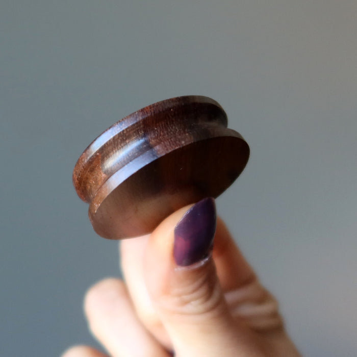 hand holding a rosewood display stand
