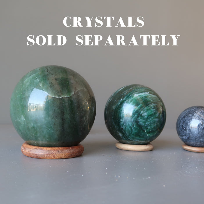 three balls dispaying on 3 wooden ring stands 