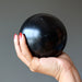 hand holding a black basalt sphere
