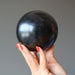 hand holding a black basalt sphere