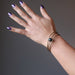 female hand wearing bloodstone coil bracelet