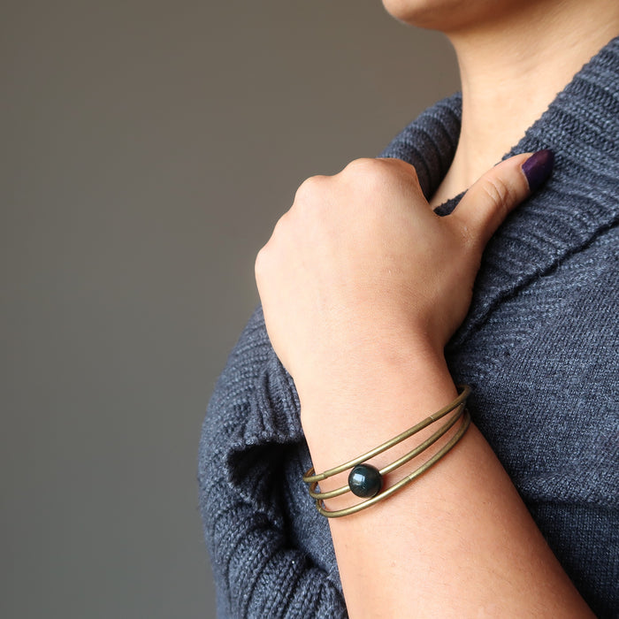 female hand wearing bloodstone coil bracelet