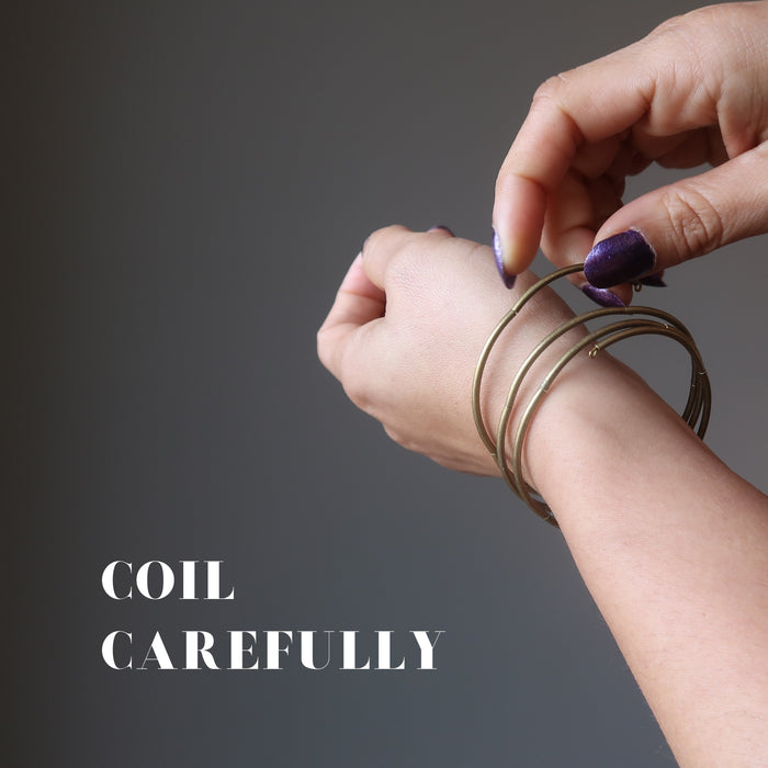 female hand wearing bloodstone coil bracelet