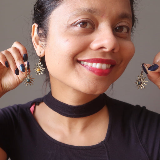 woman holding bloodstone sun earrings
