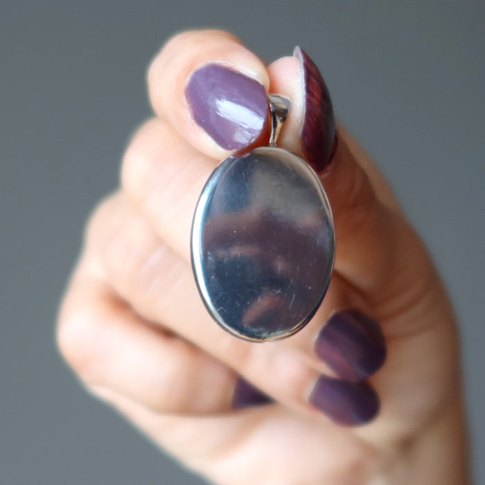 hand holding indian bloodstone pendant showing metal back