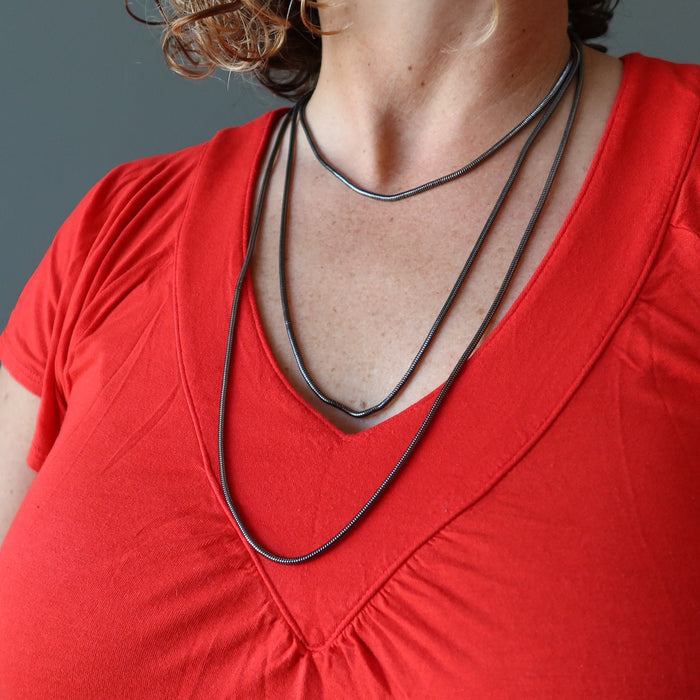 female model wearing gunmetal snake chain necklaces showing different lengths