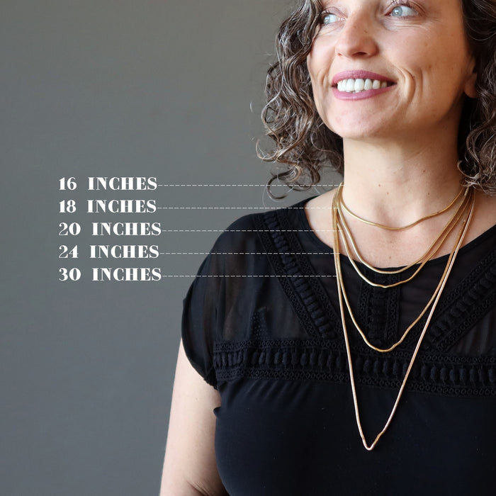 aleks of satin crystals wearing 5 gold plated brass snake chain necklaces to show the different lengths