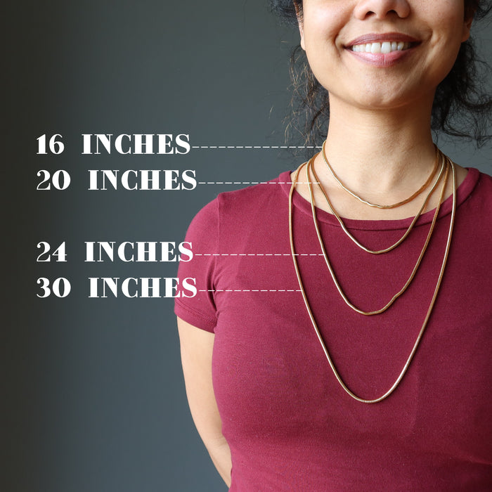 female model of satin crystals wearing 4 gold plated brass snake chain necklaces to show the different lengths