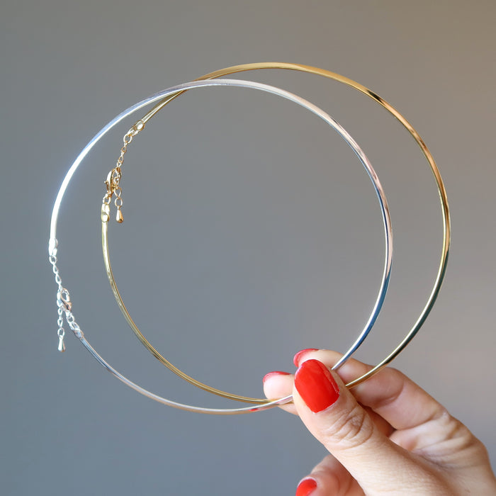 holding  Pair of Gold and Silver plated brass Neckwire choker necklaces 