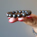 hand holding a bronzite bracelet