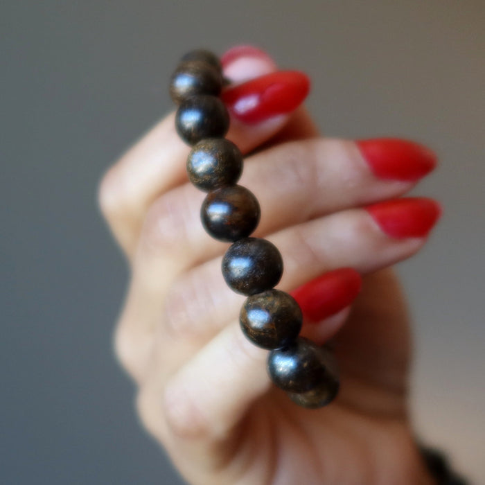 hand holding a bronzite bracelet