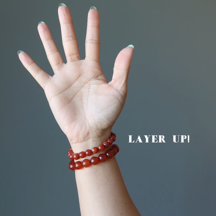 female hand model wearing carnelian bracelet