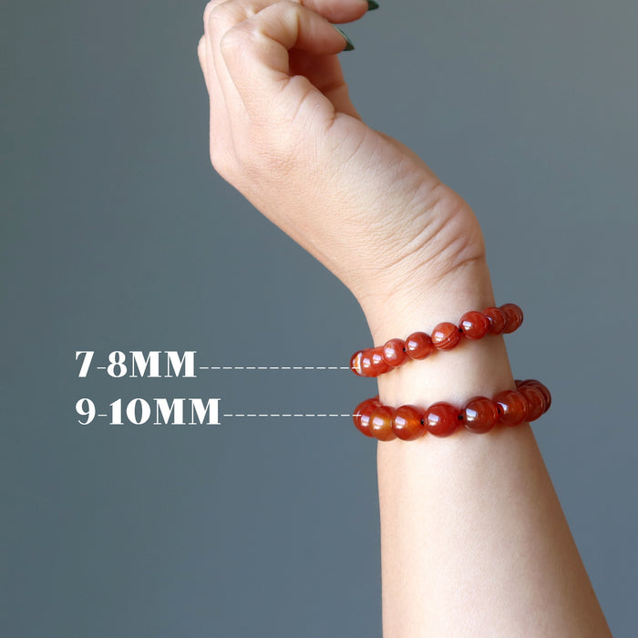 wrist wearing different size carnelian beads