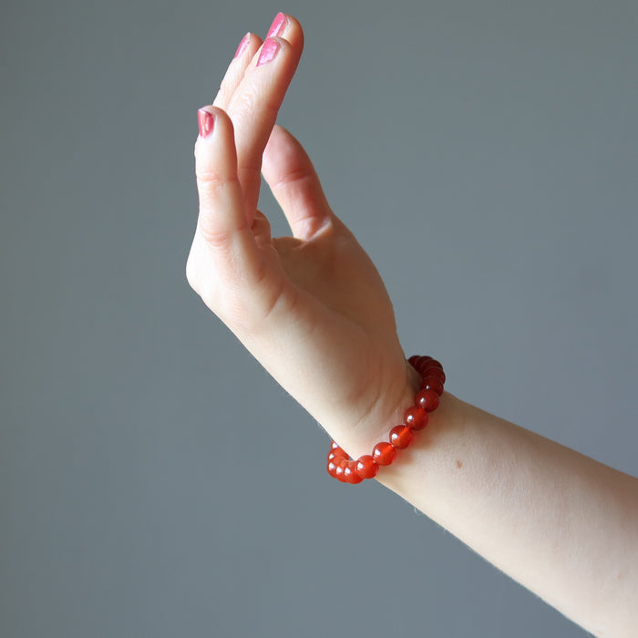 female hand model wearing carnelian bracelets