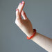 female hand model wearing carnelian bracelets