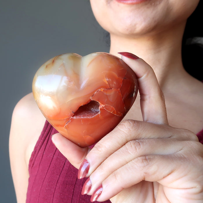 holding Orange Carnelian Heart showing crater