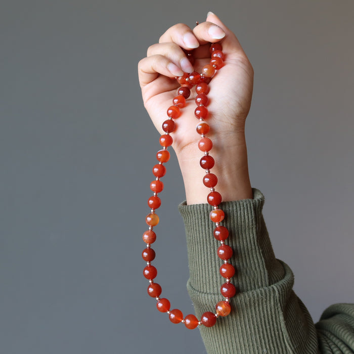 hand holding carnelian copper beaded necklace